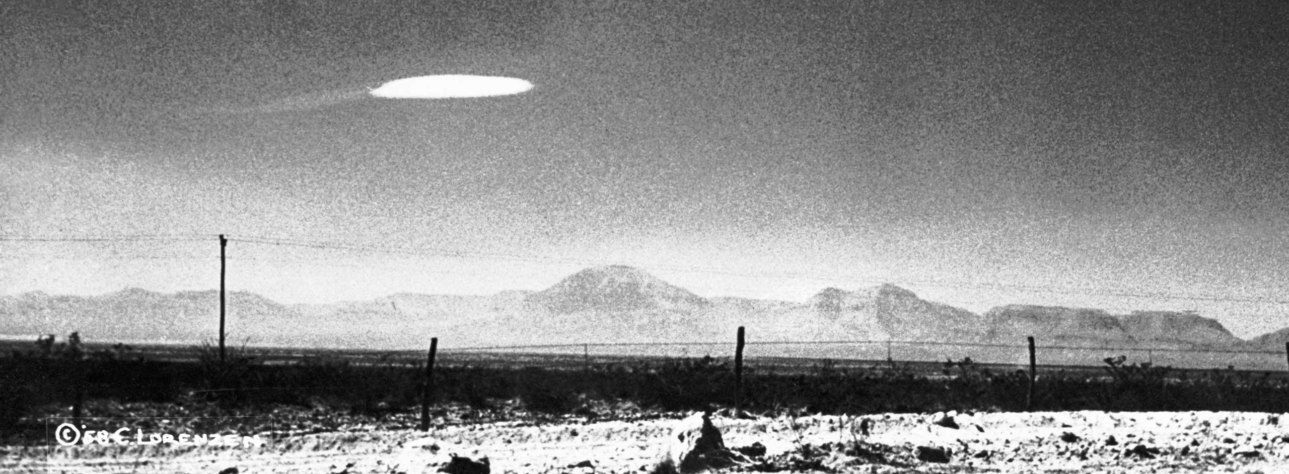 This photo was taken by Ella Fortune near the Holloman North Test Range in New Mexico, while driving along Highway 54. The object appeared motionless and there was no wind at the time. Skeptics believe this may have been a lenticular cloud, however, Ella Fortune was convinced this object was a UFO.